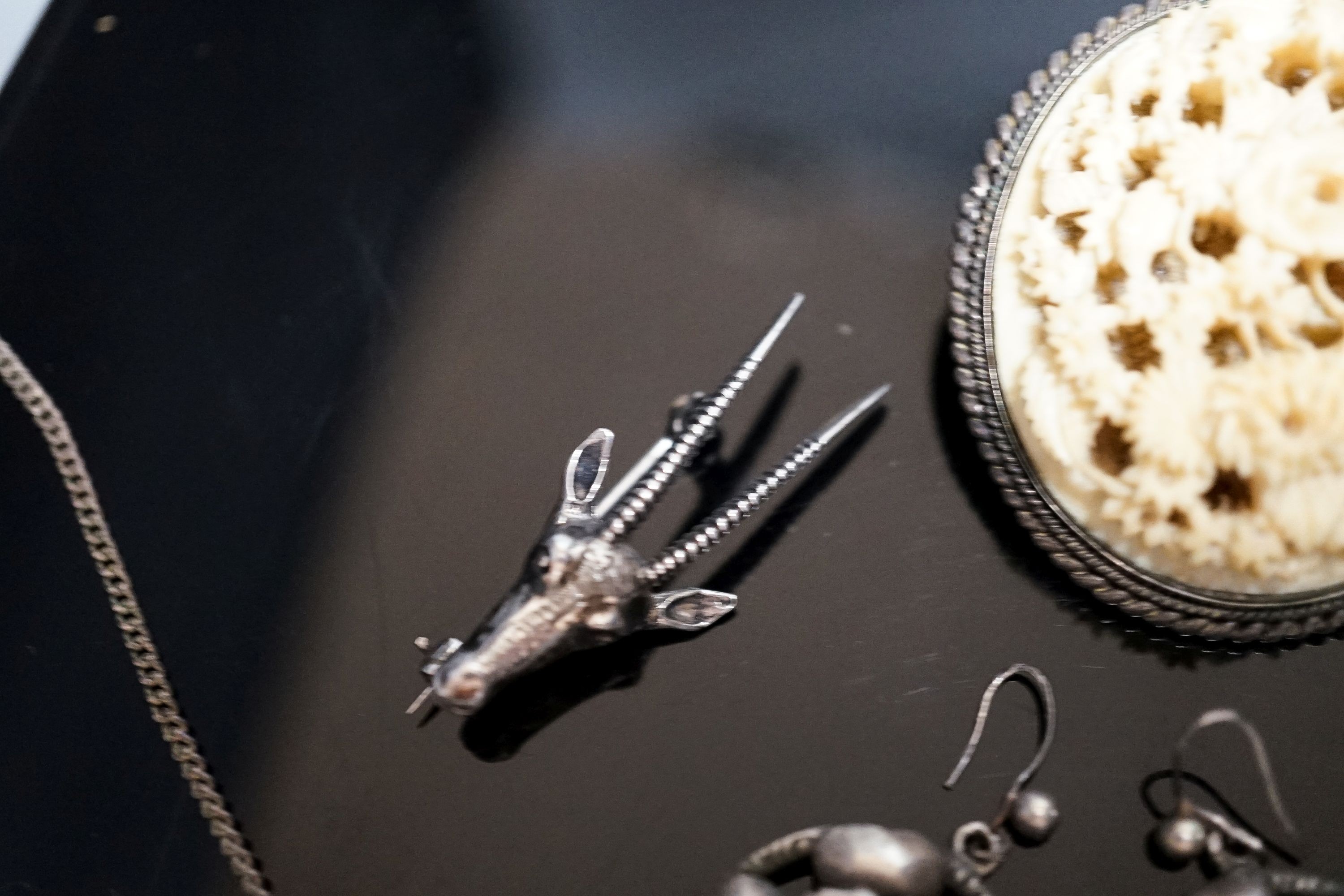 A pair of white metal and turquoise set earrings, a gem set necklace, deer head brooch and two oval brooches.